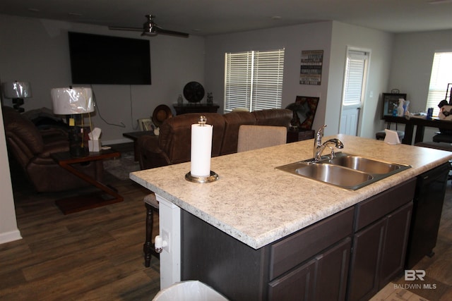 kitchen featuring dark hardwood / wood-style flooring, sink, dark brown cabinets, and a center island with sink