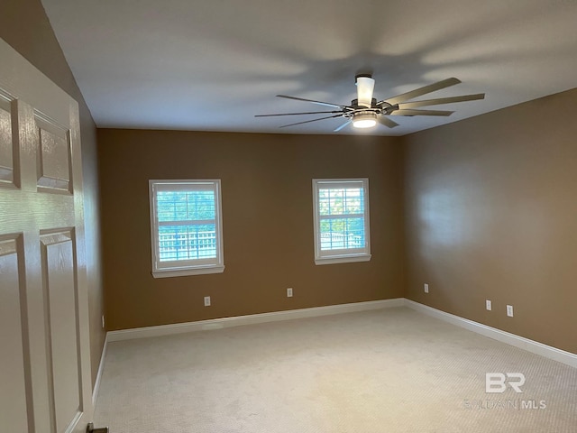 spare room with plenty of natural light, ceiling fan, and light colored carpet