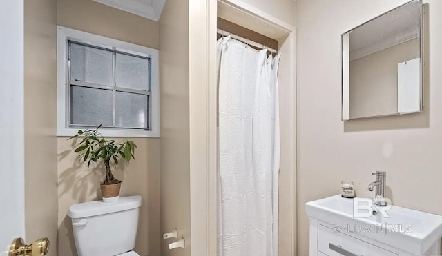 bathroom with toilet, crown molding, and vanity