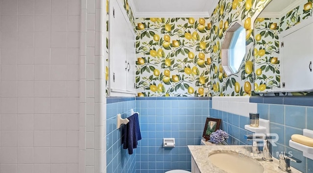 bathroom with tile walls, toilet, vanity, and ornamental molding