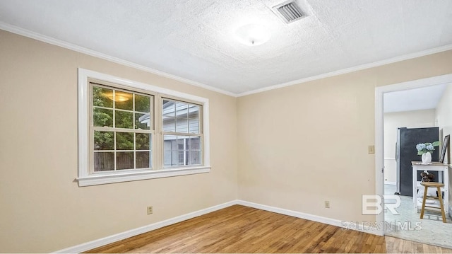 unfurnished room with ornamental molding, a textured ceiling, and hardwood / wood-style flooring