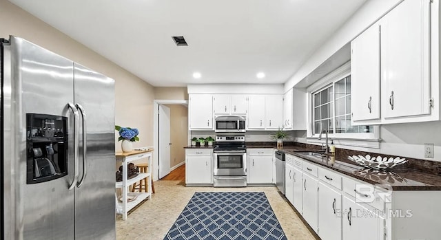 kitchen featuring stainless steel appliances, white cabinetry, and sink