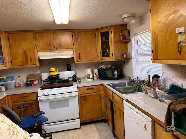 kitchen featuring white appliances, a textured ceiling, and sink