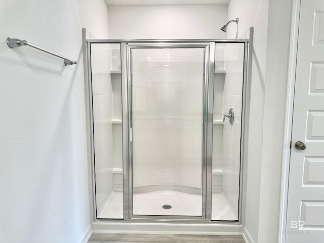1036 Hayward Loop, Foley, AL 36535 - bathroom featuring a stall shower, wood finished floors, and baseboards