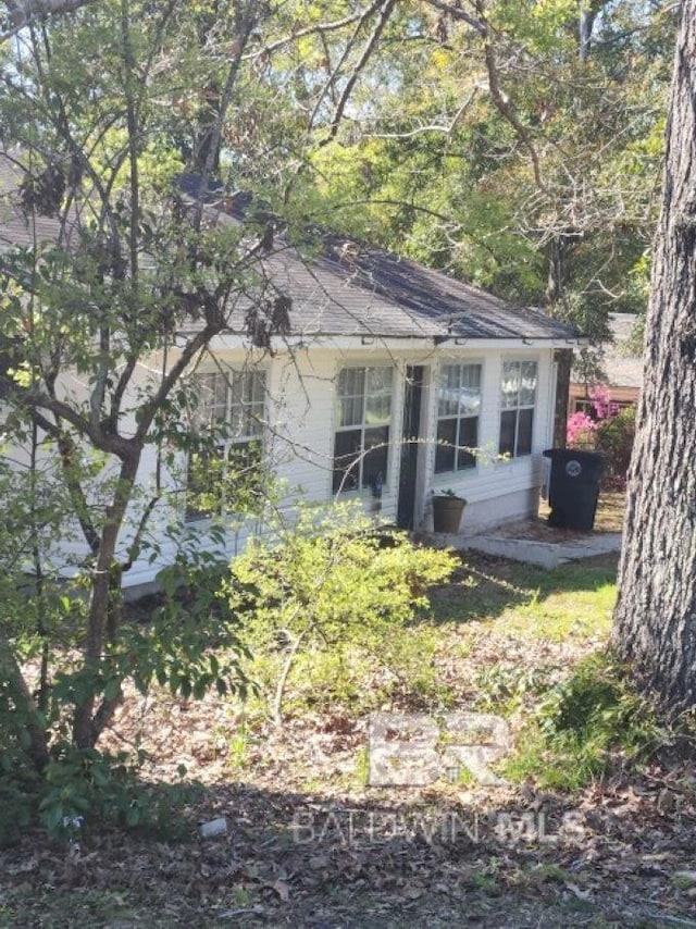 view of side of home featuring roof with shingles