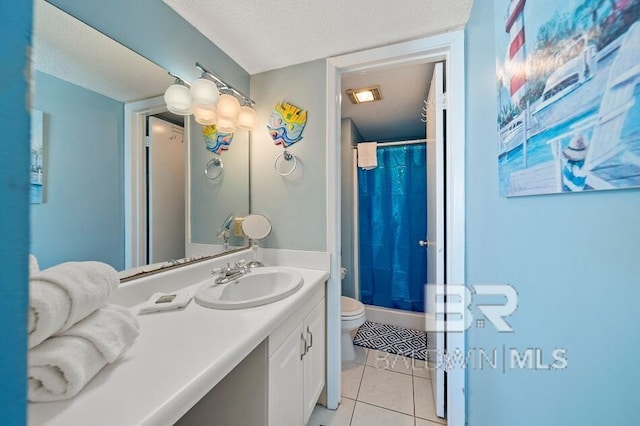 bathroom with tile patterned flooring, toilet, vanity, and a textured ceiling