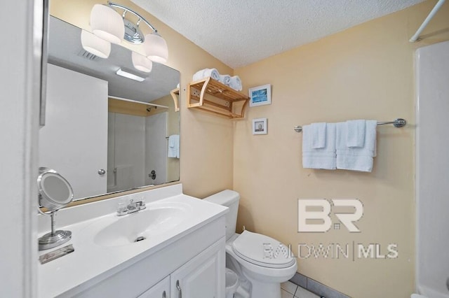 bathroom featuring vanity, toilet, tile patterned floors, and a textured ceiling