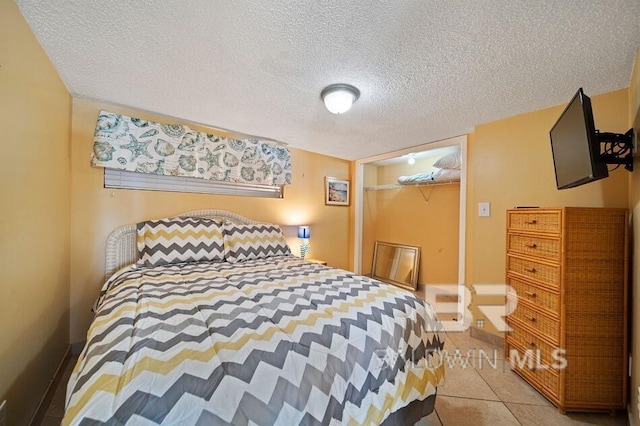 tiled bedroom featuring a textured ceiling and a closet