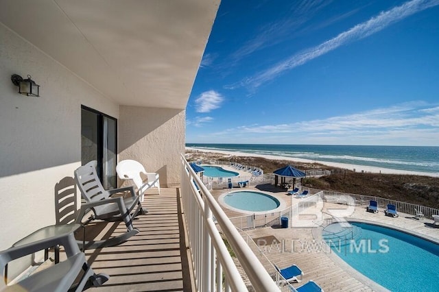 balcony featuring a water view, a community pool, and a patio area