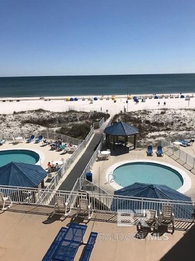 drone / aerial view featuring a water view and a beach view