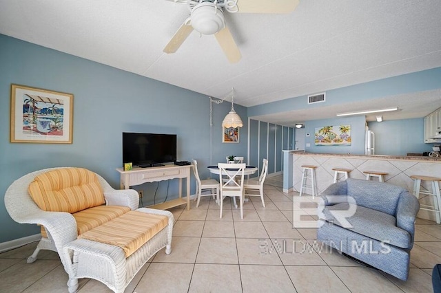 living room with track lighting, light tile patterned floors, and ceiling fan