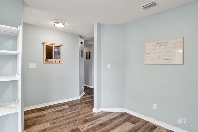 unfurnished room featuring wood finished floors and baseboards