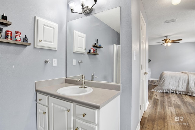 bathroom featuring wood finished floors, ceiling fan, vanity, and ensuite bath