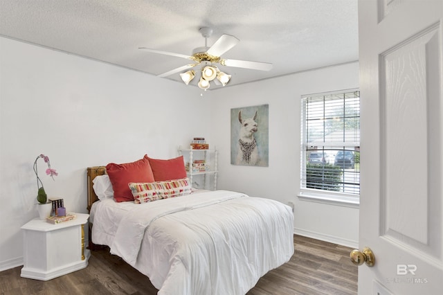 bedroom featuring dark wood finished floors, a textured ceiling, baseboards, and a ceiling fan