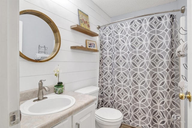 bathroom featuring toilet, vanity, a textured ceiling, and a shower with shower curtain