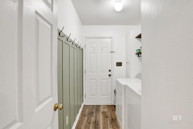 mudroom with washing machine and dryer, a textured ceiling, and dark wood-style flooring