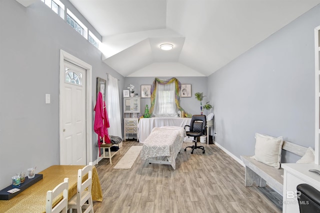 sitting room featuring light wood-style floors, baseboards, and vaulted ceiling