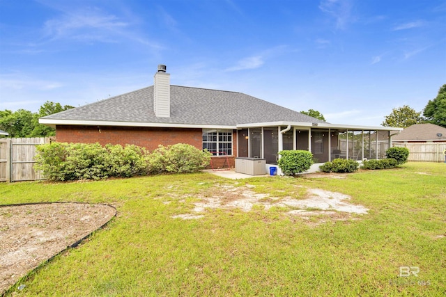 back of property with a sunroom, brick siding, a chimney, and a shingled roof