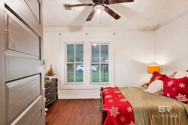 bedroom with crown molding, ceiling fan, and dark hardwood / wood-style flooring