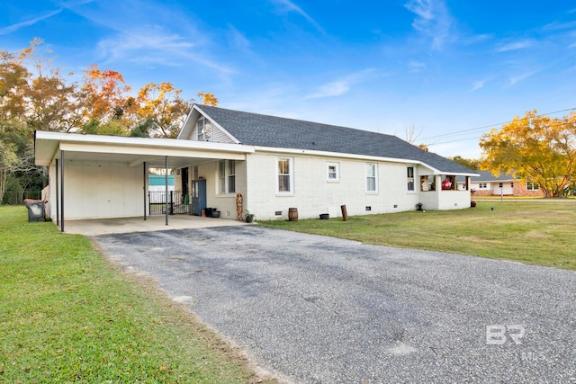 rear view of house featuring a carport and a lawn