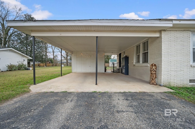 view of parking / parking lot with a carport and a yard