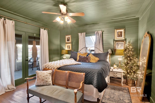 bedroom featuring access to exterior, wood ceiling, light hardwood / wood-style flooring, and french doors