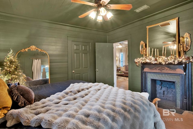 bedroom with wooden walls and ceiling fan