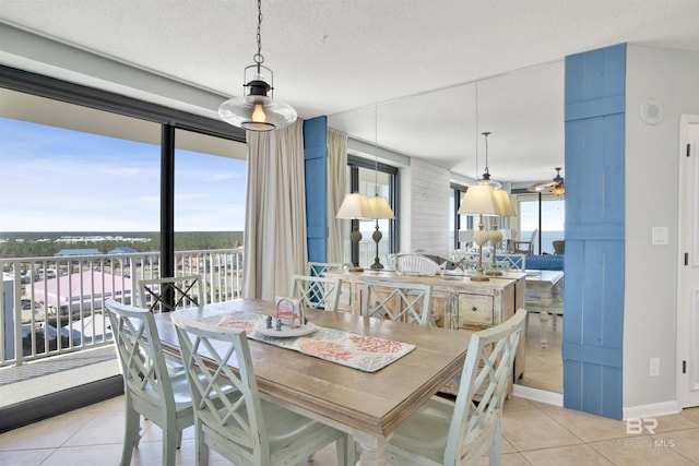 dining room with plenty of natural light, a textured ceiling, baseboards, and light tile patterned floors