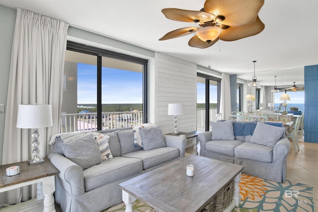 living room featuring a ceiling fan, light tile patterned flooring, and plenty of natural light