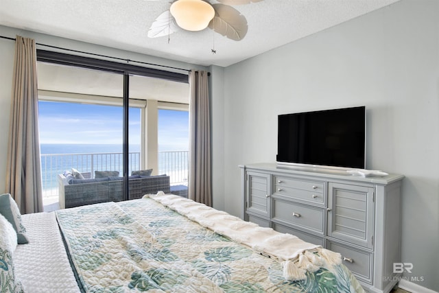 bedroom with a ceiling fan, access to outside, a textured ceiling, and baseboards