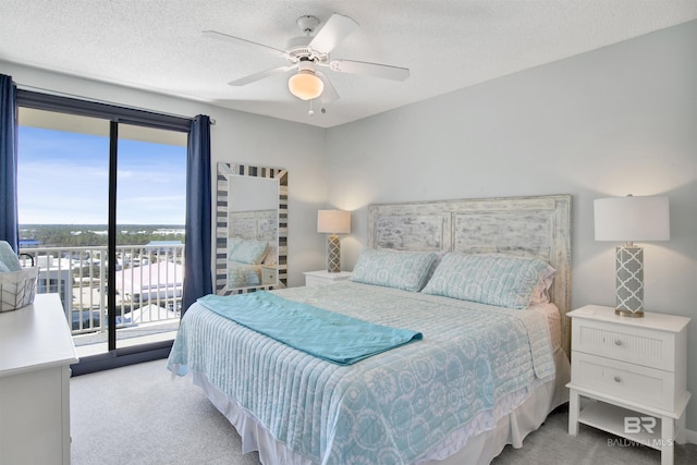 carpeted bedroom with access to exterior, a textured ceiling, and a ceiling fan