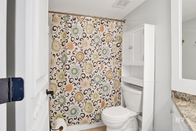 bathroom featuring toilet, vanity, and visible vents