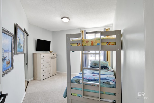 bedroom featuring carpet flooring, a textured ceiling, and baseboards