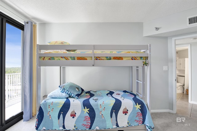 bedroom featuring access to exterior, visible vents, a textured ceiling, and carpet flooring