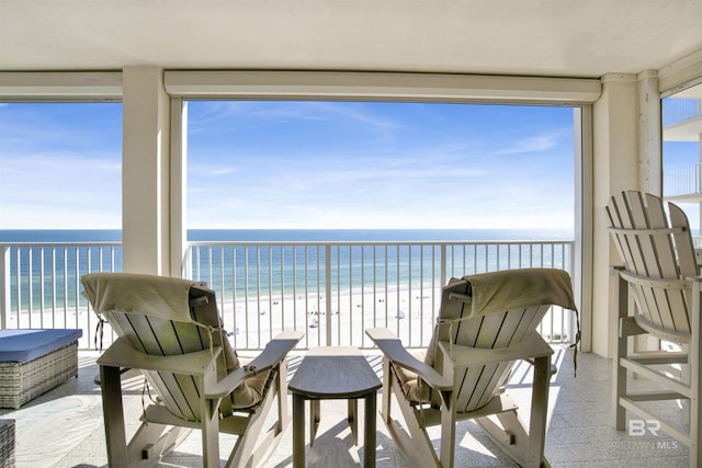 balcony featuring a water view and a beach view