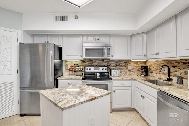 kitchen with light tile patterned floors, visible vents, decorative backsplash, appliances with stainless steel finishes, and a sink