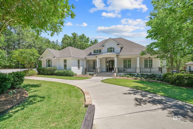 202 Paddle Creek Loop, Fairhope, AL 36532 - view of front facade with a porch, stucco siding, a front yard, curved driveway, and roof with shingles