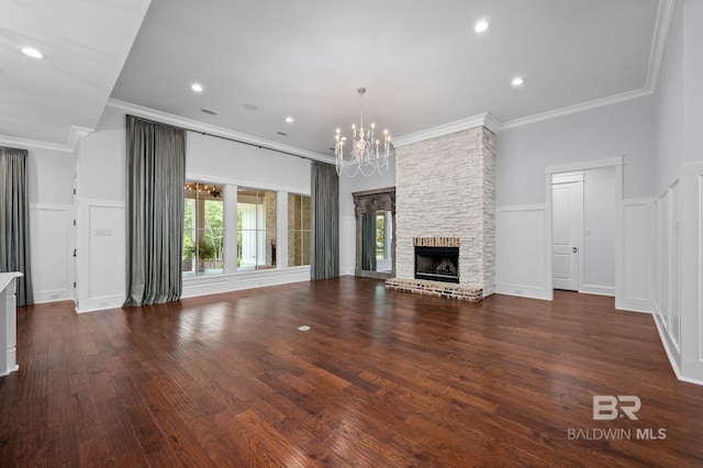 202 Paddle Creek Loop, Fairhope, AL 36532 - unfurnished living room featuring a chandelier, crown molding, wood finished floors, a fireplace, and a decorative wall