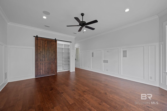 202 Paddle Creek Loop, Fairhope, AL 36532 - unfurnished bedroom with a decorative wall, crown molding, a barn door, wood finished floors, and a wainscoted wall