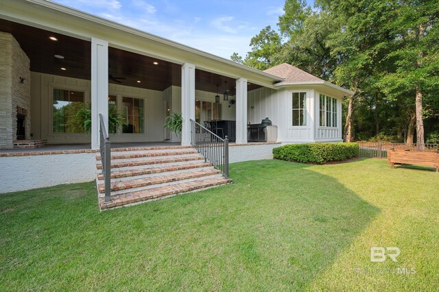 202 Paddle Creek Loop, Fairhope, AL 36532 - back of property with board and batten siding, a lawn, and a patio area