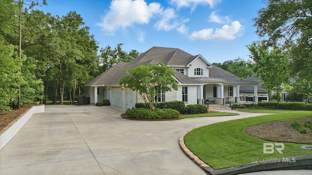 202 Paddle Creek Loop, Fairhope, AL 36532 - view of front facade with stucco siding, concrete driveway, a porch, an attached garage, and a front yard
