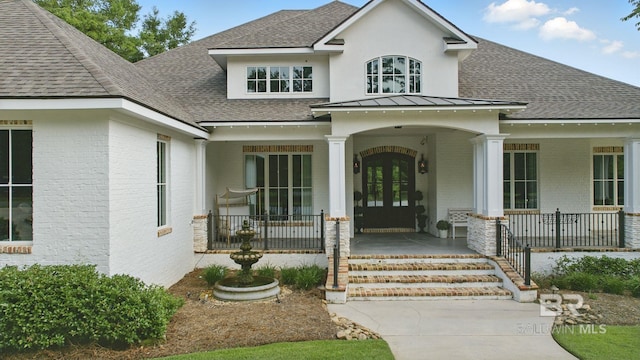 202 Paddle Creek Loop, Fairhope, AL 36532 - doorway to property with brick siding, roof with shingles, covered porch, a standing seam roof, and french doors