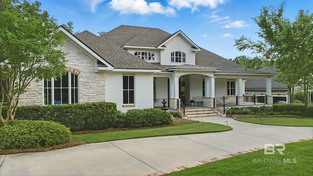 202 Paddle Creek Loop, Fairhope, AL 36532 - view of front facade featuring stone siding, covered porch, a shingled roof, stucco siding, and a front lawn