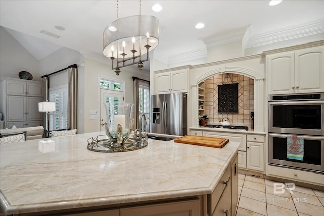 kitchen featuring pendant lighting, stainless steel appliances, light tile patterned flooring, and a center island with sink