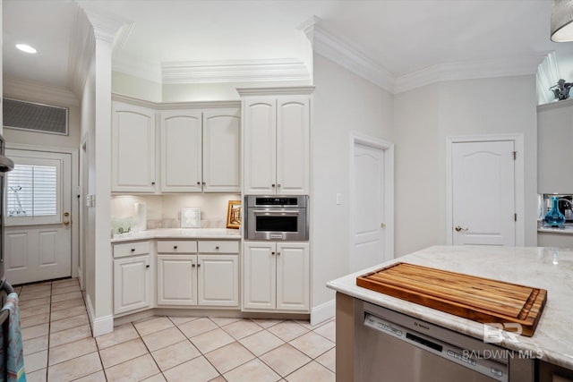 kitchen with ornamental molding, light tile patterned flooring, white cabinets, and appliances with stainless steel finishes