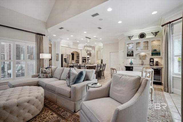 tiled living room featuring lofted ceiling, indoor wet bar, beverage cooler, ornamental molding, and a notable chandelier