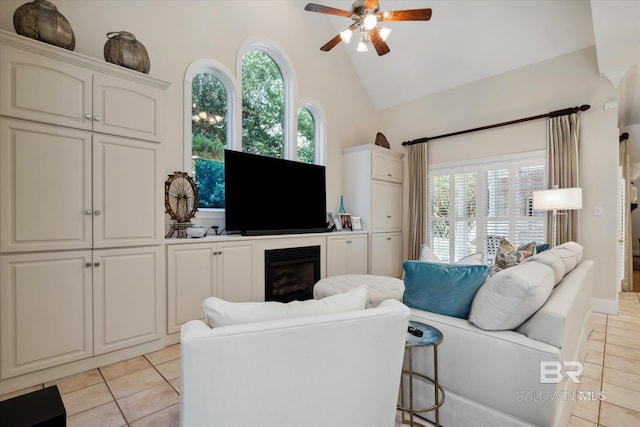 tiled living room featuring ceiling fan and high vaulted ceiling