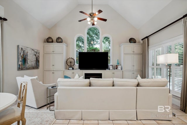 living room with ceiling fan, high vaulted ceiling, and light tile patterned floors