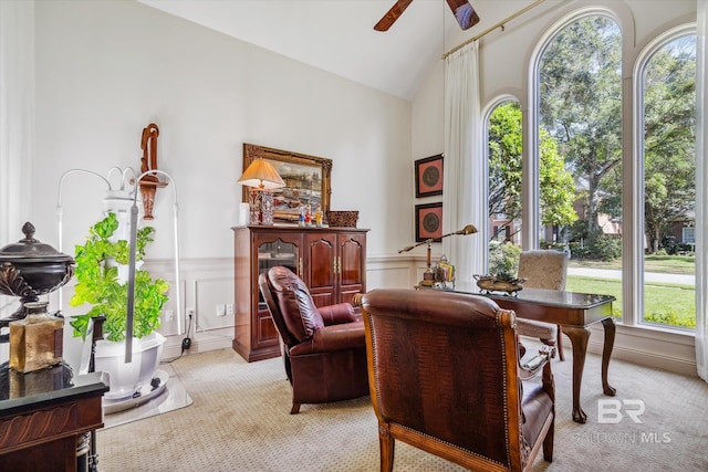 sitting room with high vaulted ceiling, light colored carpet, and ceiling fan