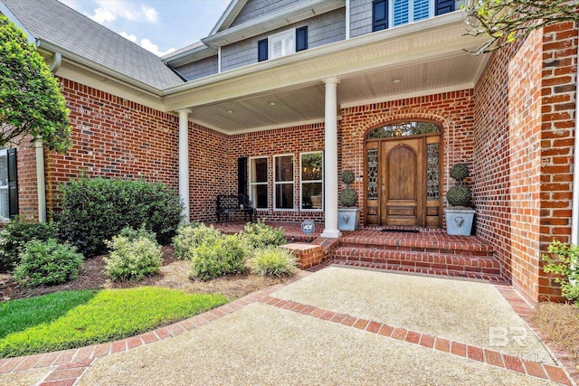 view of exterior entry featuring covered porch